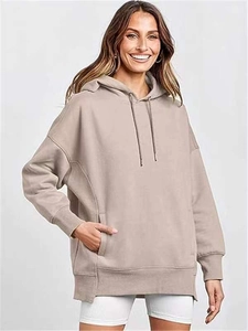 Close-up of women's warm brown oversized hoodie featuring a kangaroo pocket and side slits
