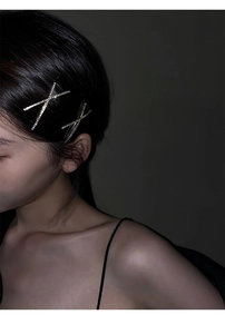Close-up of sparkling X-shaped rhinestone hair clips worn on a model side profile