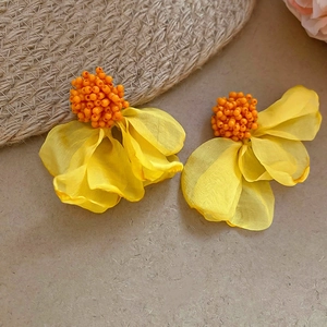 Detail of yellow chiffon flower earrings with orange bead centers and petal textures