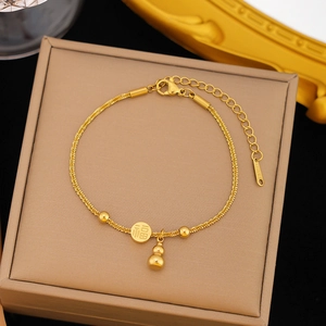 Golden stainless steel bracelet featuring gourd and lucky Fu character charms on a jewelry box