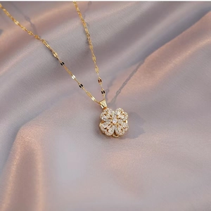 Elegante goldene Kleeblatt-Halskette mit Zirkonia-Steinen auf Seidenhintergrund