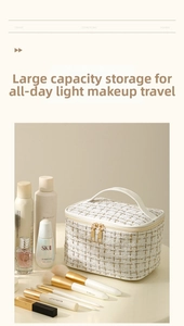 Close-up of cream tweed makeup bag featuring gold zippers and reinforced top handle