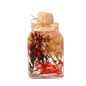 Minimalist reed diffuser glass bottle with red and white dried flowers for home decor