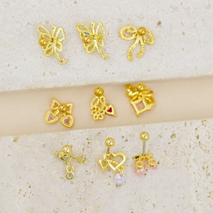 Macro detail of nine gold piercing studs including butterfly and cherry shapes on stone