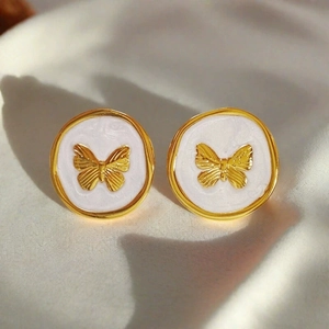 French vintage gold butterfly earrings with white enamel on soft silk background