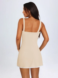 Vista dettagliata dell'elegante pizzo sull'orlo di questo abito sottoveste beige