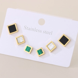 Detail of square stainless steel stud earrings in black, white pearl, and green stripe