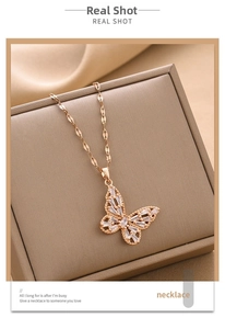 Macro detail of rose gold butterfly pendant necklace with inlaid zircon on leather box