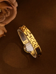 Detailed close-up of golden link watch band featuring brown tortoiseshell resin inlays