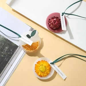 Flat lay of handmade scented wax tablets with dried flowers and green ribbons