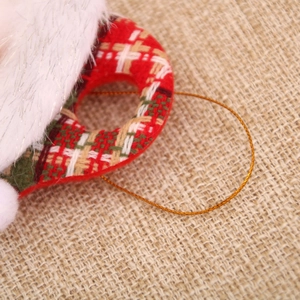 Close-up of Christmas fabric ornament with red-green plaid pattern and white plush trim
