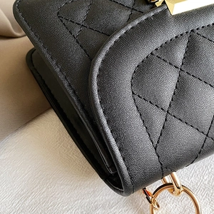 Detalle de bolso en cuero acolchado negro con costuras finas y herrajes dorados
