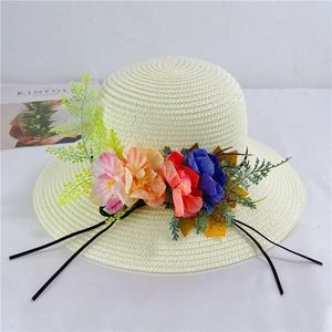 Detailed close-up of cream woven straw hat decorated with colorful floral embellishments