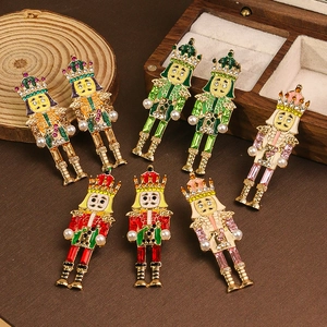 Colorful Nutcracker soldier brooch with rhinestones and pearls on vintage wooden background