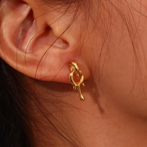 Macro close-up of 18K gold plated earrings featuring a unique molten liquid drop design