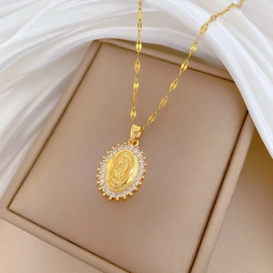 Gold-plated oval Virgin Mary pendant necklace with zircon halo on beige jewelry box