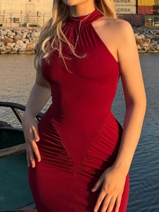 Close-up of ruched side details on a tight red halter dress with slim fit tailoring