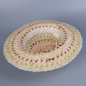 Detail of bohemian straw hat with colorful X-shaped stitching and interior care label