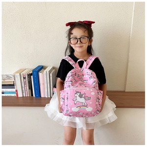 Pink unicorn kids backpack with side pocket and adjustable straps worn by a young girl