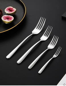 Close-up of four different sized polished 304 stainless steel forks on black background