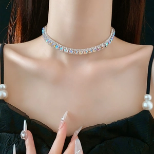 Close-up of a silver square crystal necklace on a model with a black background