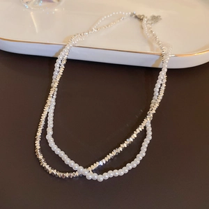 Close-up of double-layer necklace with faceted silver beads and white pearls details