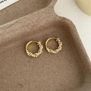 Detailed view of vintage gold hoop earrings with intricately wrapped white pearls