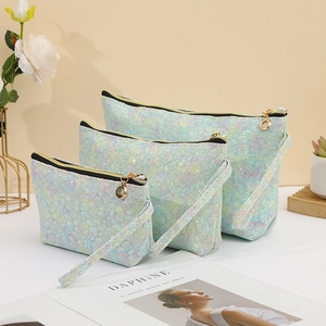 Three-piece set of shimmering blue lace toiletry bags with fish scale texture detail