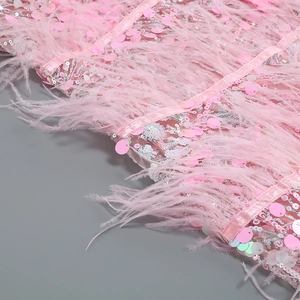 Close-up of pink sequin fabric with ostrich feathers on the mesh evening dress detail