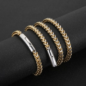 Detail of two-tone gold and silver stainless steel wheat chain necklace with clasp