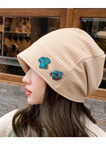 Detail of creative medical enamel pins on beige knit hat featuring nurse and doctor design