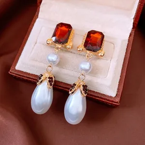 Vintage gold earrings with red gemstones and elegant white water drop pearl pendants