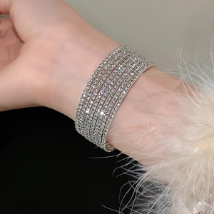 Macro-opname van zilveren gelaagde strass-armband met glanzende kristallen op de pols