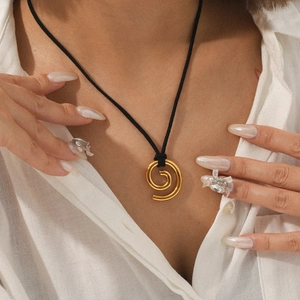 Close-up of 18K gold-plated spiral pendant with black rope chain on female neck