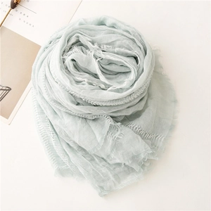 Close-up of soft pleated cotton linen scarf in mint green with fringe edge details