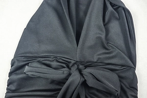 Detail of the plunging V-neckline and tie-knot waist on this slim black dress