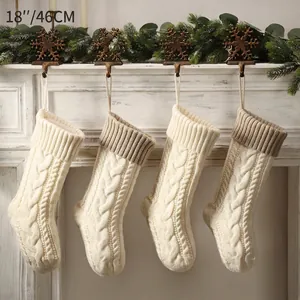 Set of four 18 inch knitted Christmas stockings in cream and brown on a white fireplace