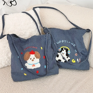 Detail of striped canvas bag with 3D puppy embroidery and Puppyland text detail