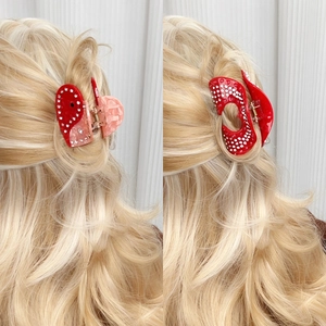 Pinces à cheveux en forme de cœur en acétate avec strass portées sur modèle