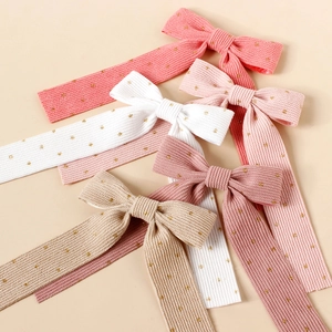 Girls corduroy bow hair clips with gold polka dots in pink, beige, and white colors