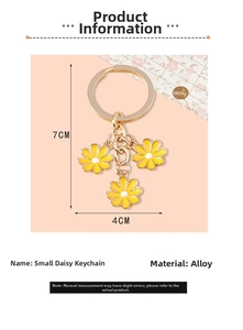 Detailed view of daisy keychain with yellow enamel flowers and golden alloy metal clasp