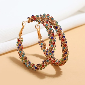 Fashionable gold hoop earrings with colorful rhinestones on a clean minimalist background