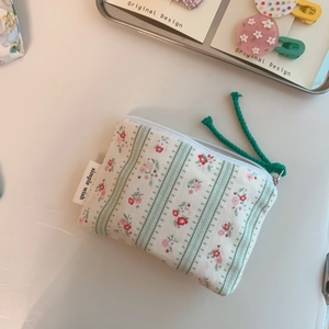 Detail of floral printed mini cotton pouch with zipper pull and simple wish label