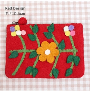 Detail of red handmade wool felt pouch with 3D floral appliques and tassel zipper closure