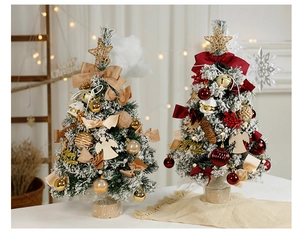Detail of mini flocked Christmas trees with gold ornaments and red ribbons on a table