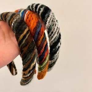 Three colorful knitted headbands in striped wool patterns for a vintage winter style
