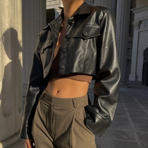 Détail de la veste courte en cuir PU noir avec revers et boutons en lumière naturelle