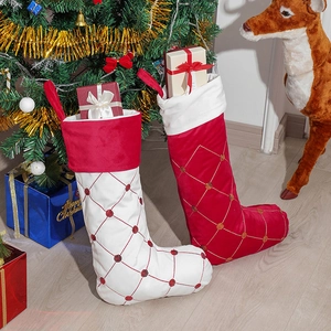 Calze natalizie in velluto trapuntato con perline rosse appese all'albero di Natale
