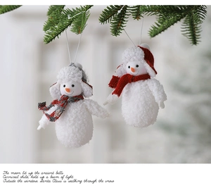 Detailed plush snowman Christmas ornament hanging on a pine branch with cozy holiday vibes