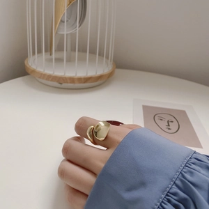 Close-up of a golden asymmetric minimalist S925 silver ring worn on a woman's hand